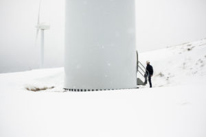 Engineer accessing to the wind turbine, in a wind farm on winter.