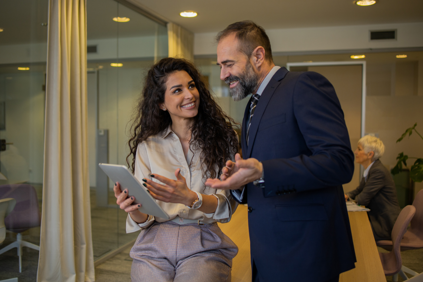 Une femme et un homme travaillant sur une tablette dans un bureau