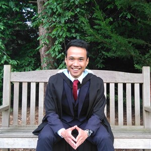 Person on a bench with graduate suit