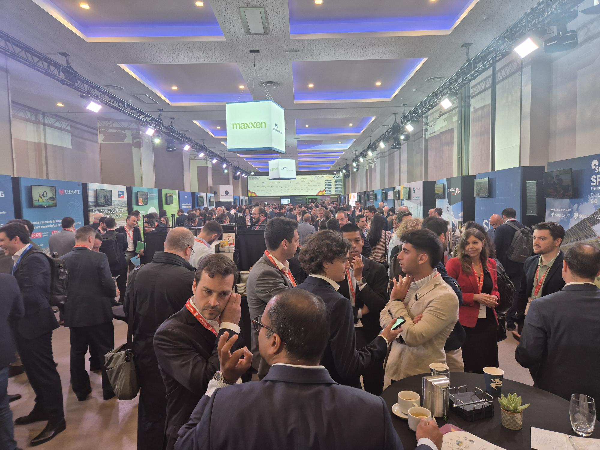 Forum où de nombreuses personnes sont réparties autour de tables et de stands